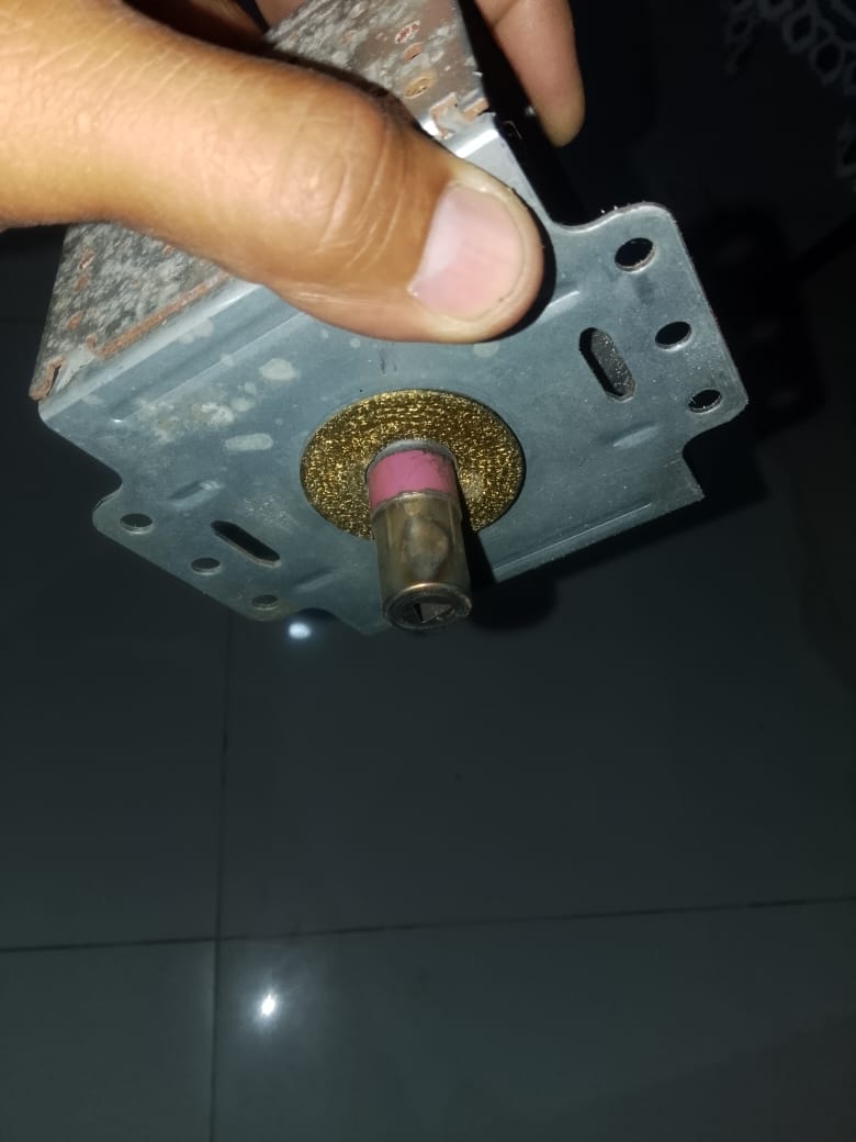 Magnetrón desmontado del microondas con desgaste en la antena, pieza dañada retirada